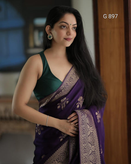 Woman wearing a green and purple saree with a blurred background