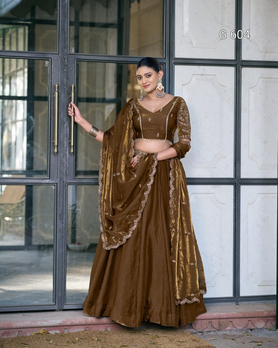 Woman in a brown traditional outfit standing in front of a glass door.